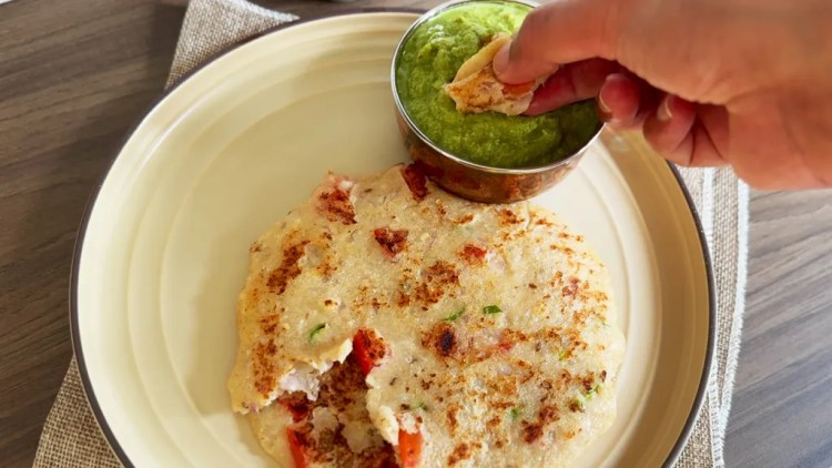 oat uttapam in a serving plate with a coriander chutney at the side